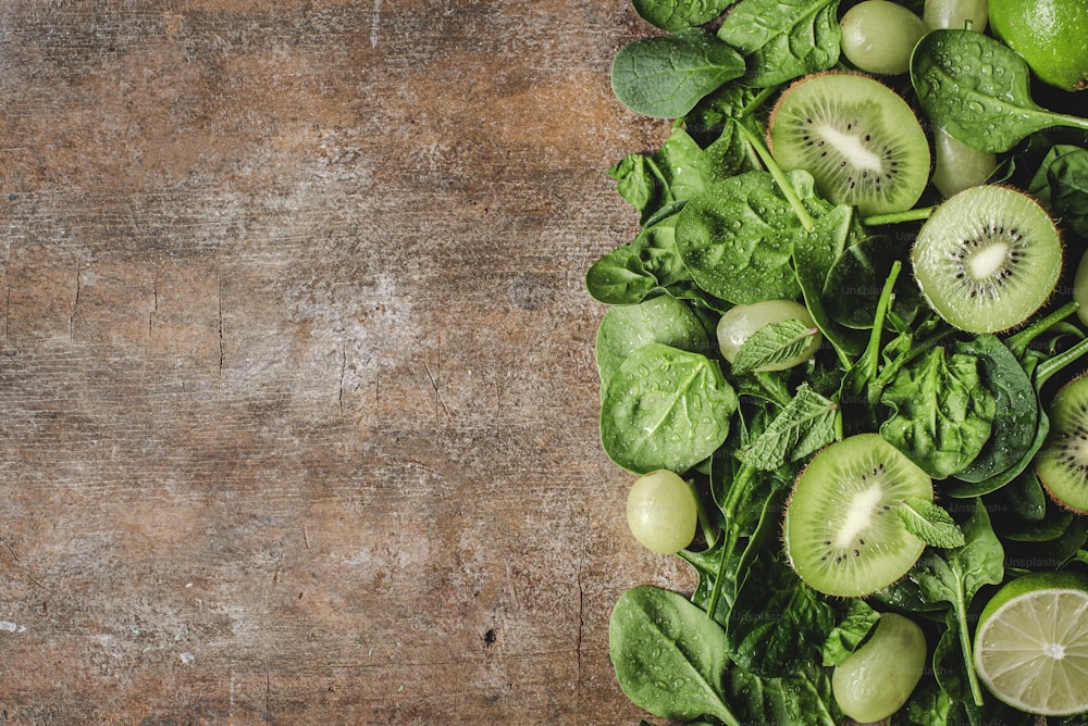 a bunch of green fruits on a wooden table