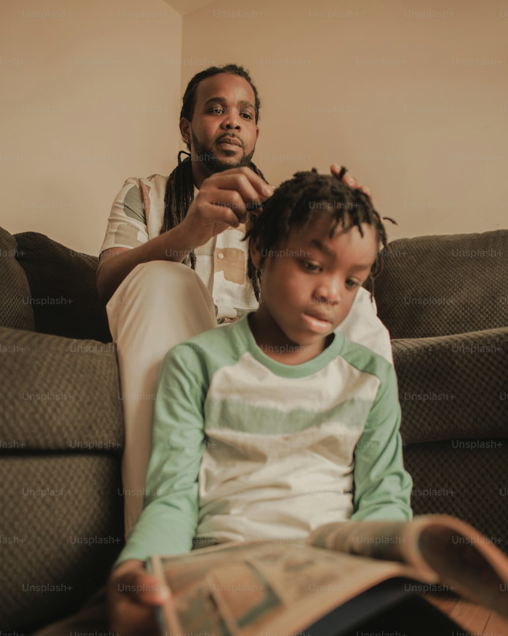 a man sitting next to a little girl on a couch