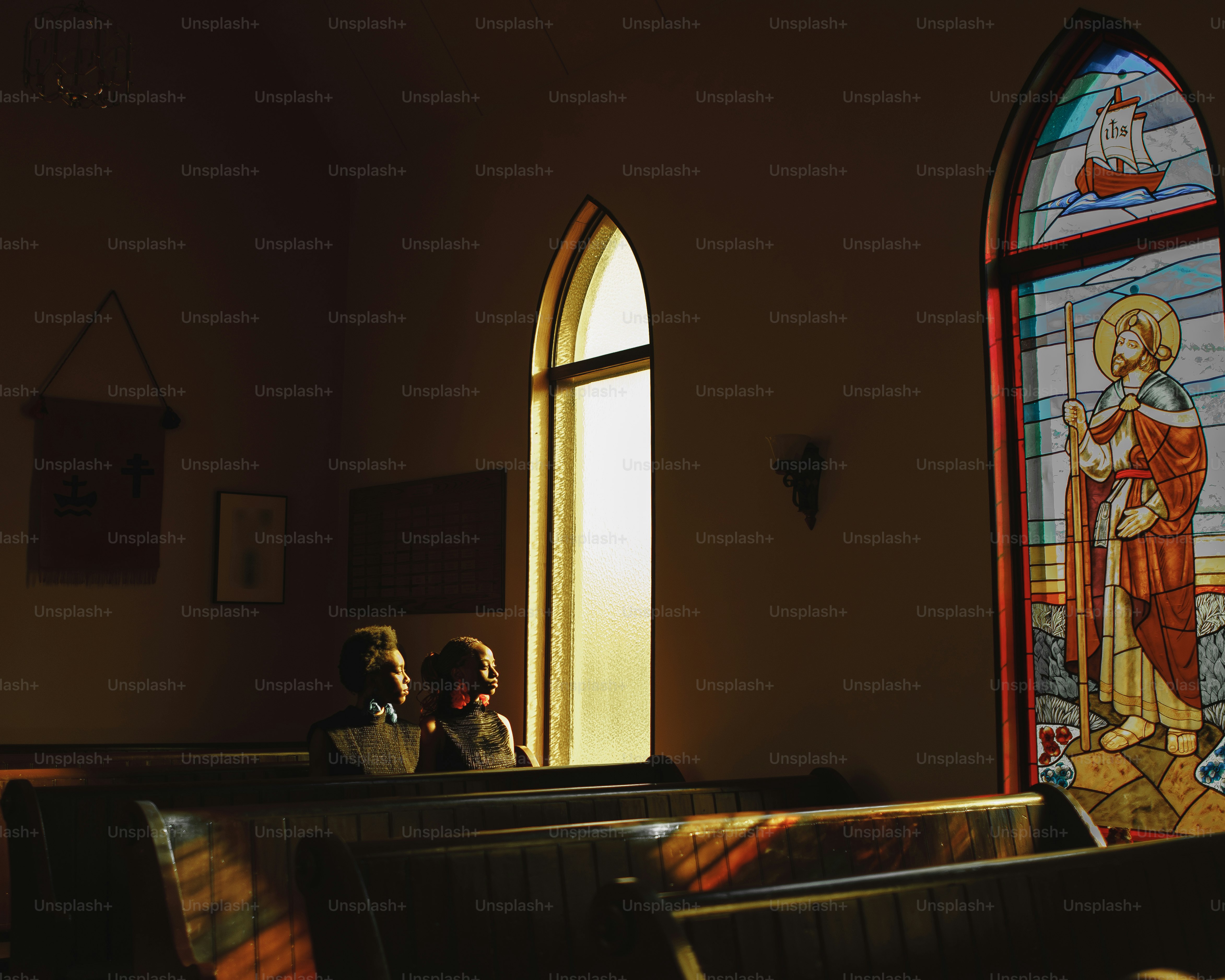 a couple of people standing in front of a stained glass window