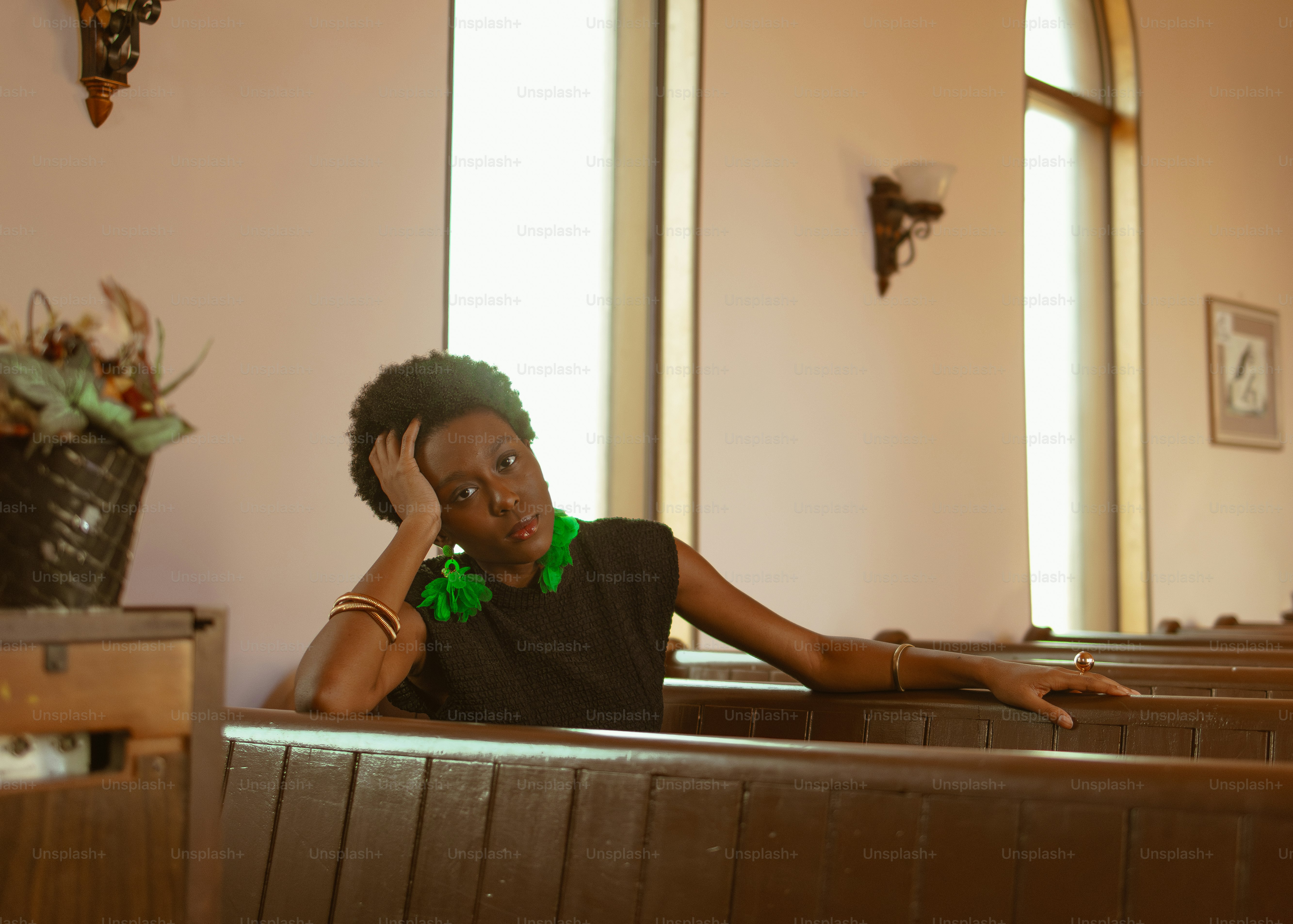 a woman sitting in a church with her hand on her head