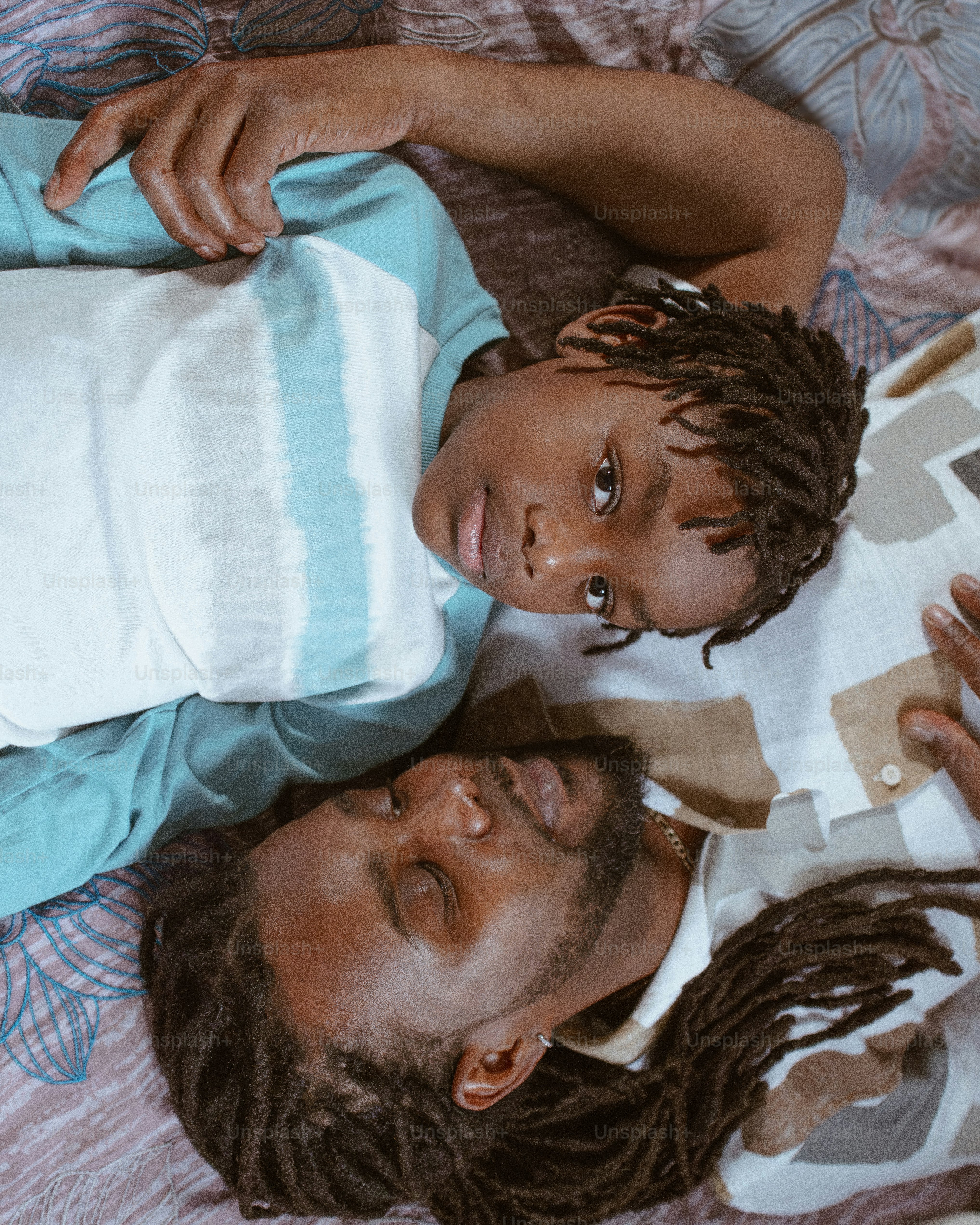 a man and a child laying on a bed