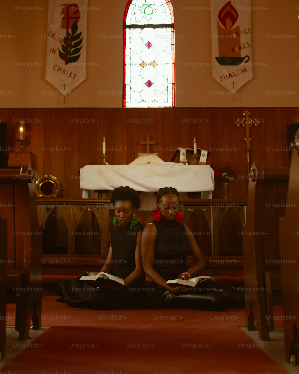 two young girls sitting on the floor of a church