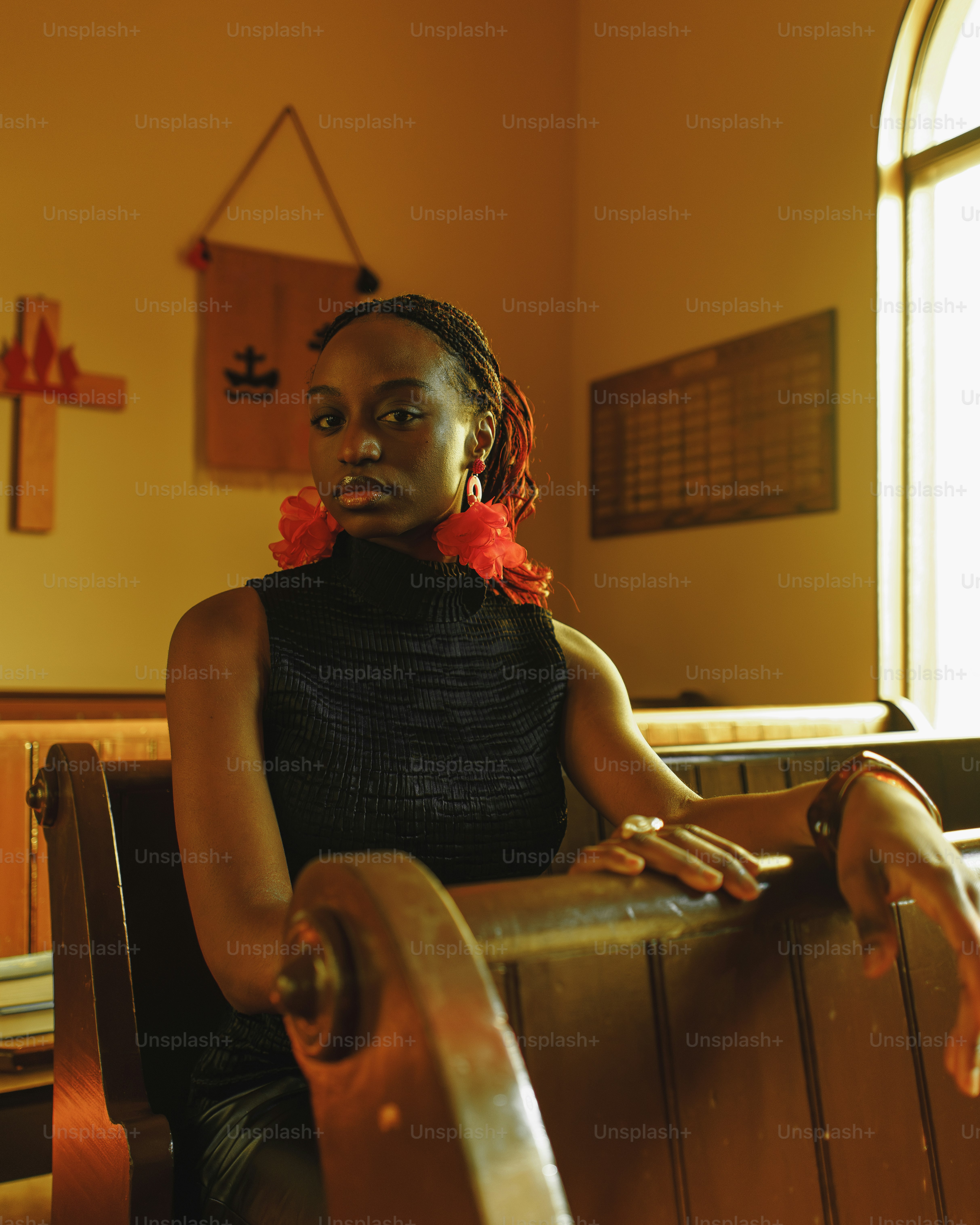 a woman sitting in a chair with a red flower in her hair