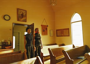 a couple of women standing next to each other in a church