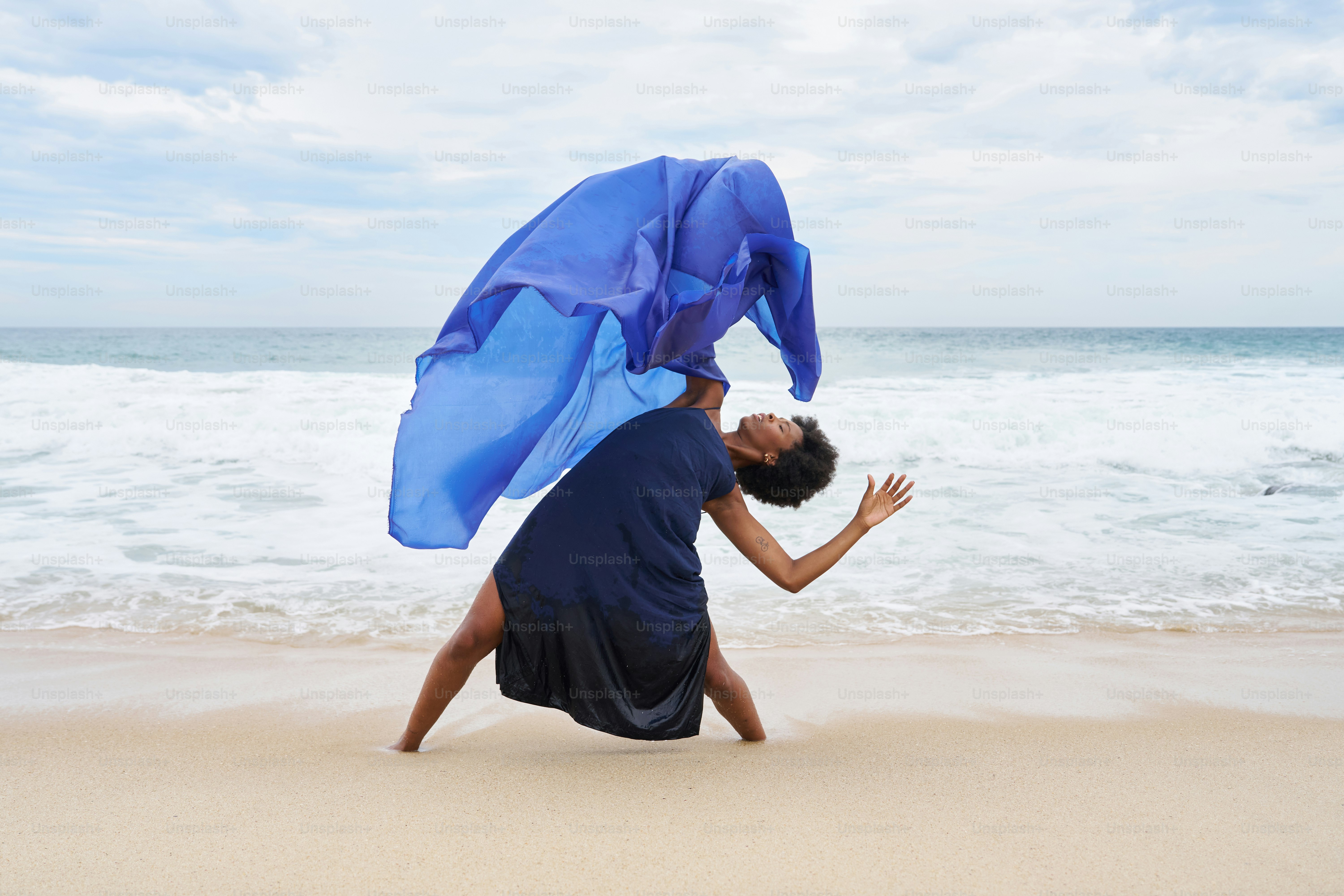 a woman in a blue dress is on the beach