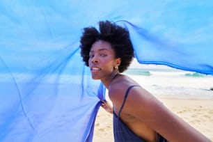 a woman with an afro standing on a beach