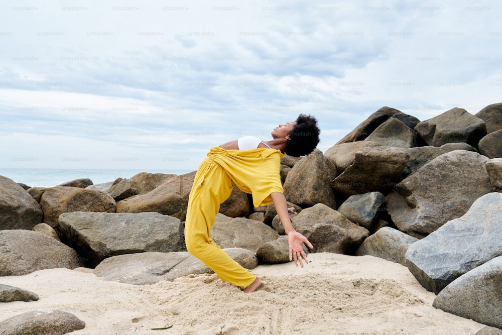 a man in a yellow outfit standing on a pile of rocks
