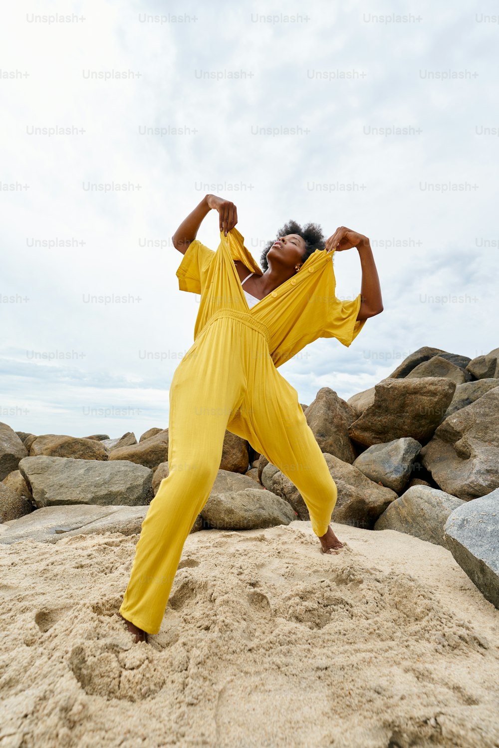 a woman standing on top of a sandy beach