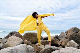 a man in a yellow outfit is standing on some rocks