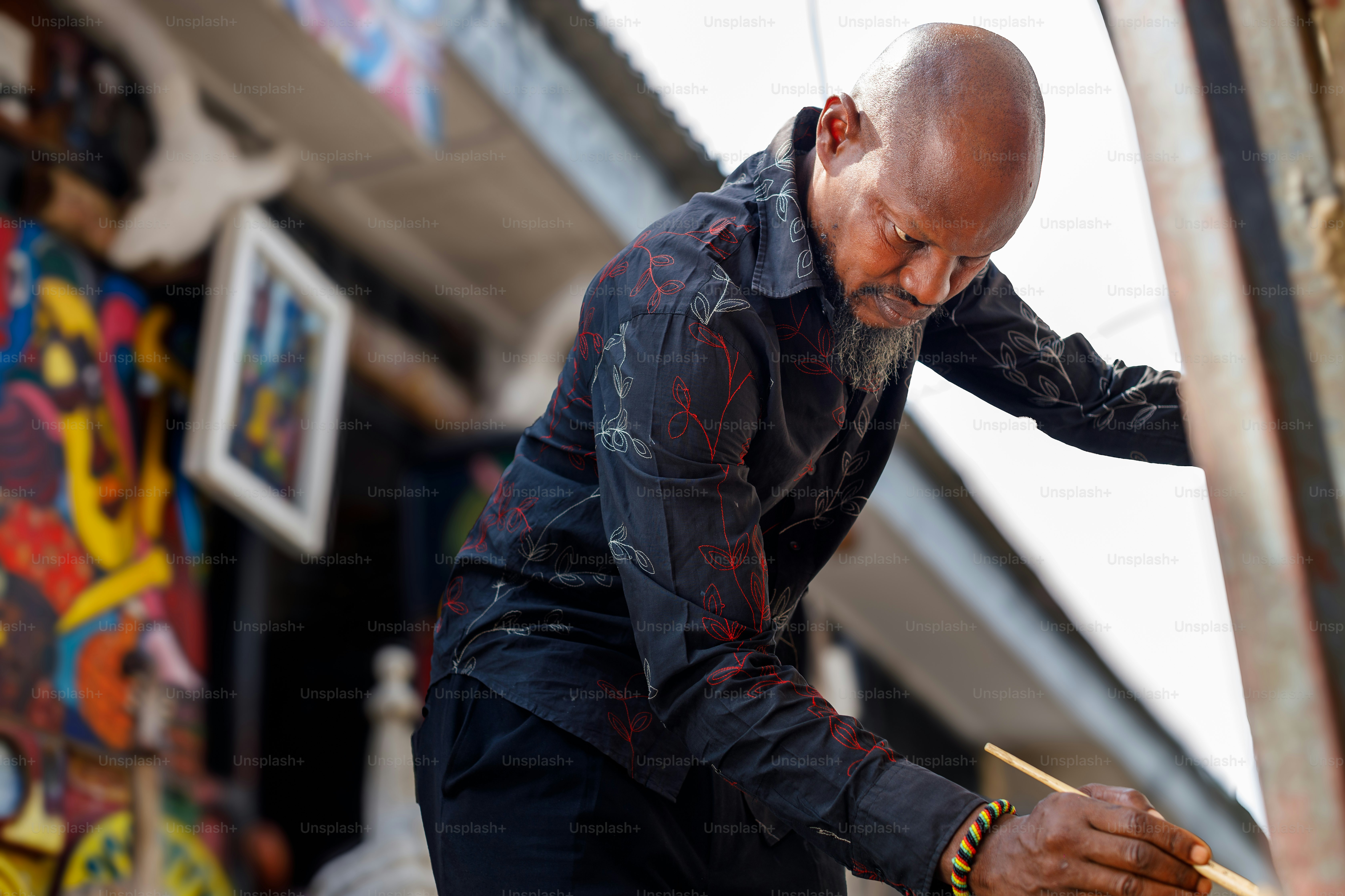 a bald man holding a pair of scissors in his right hand