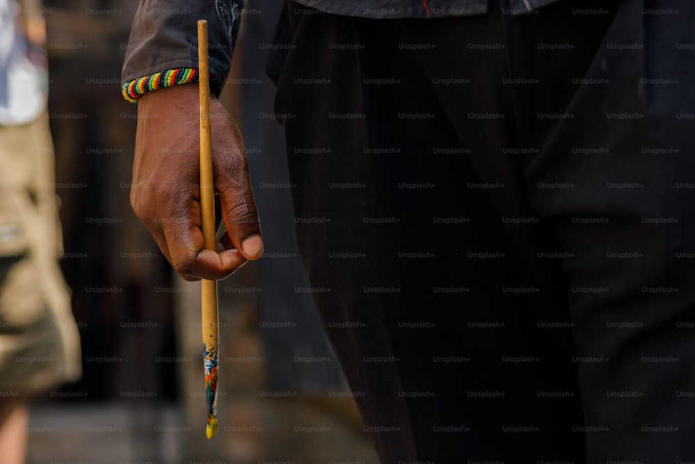 a close up of a person holding a stick