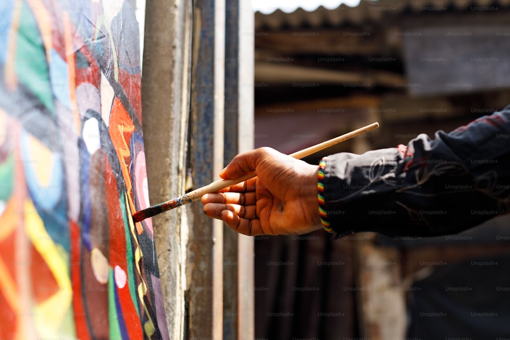 a person holding a brush and painting on a wall