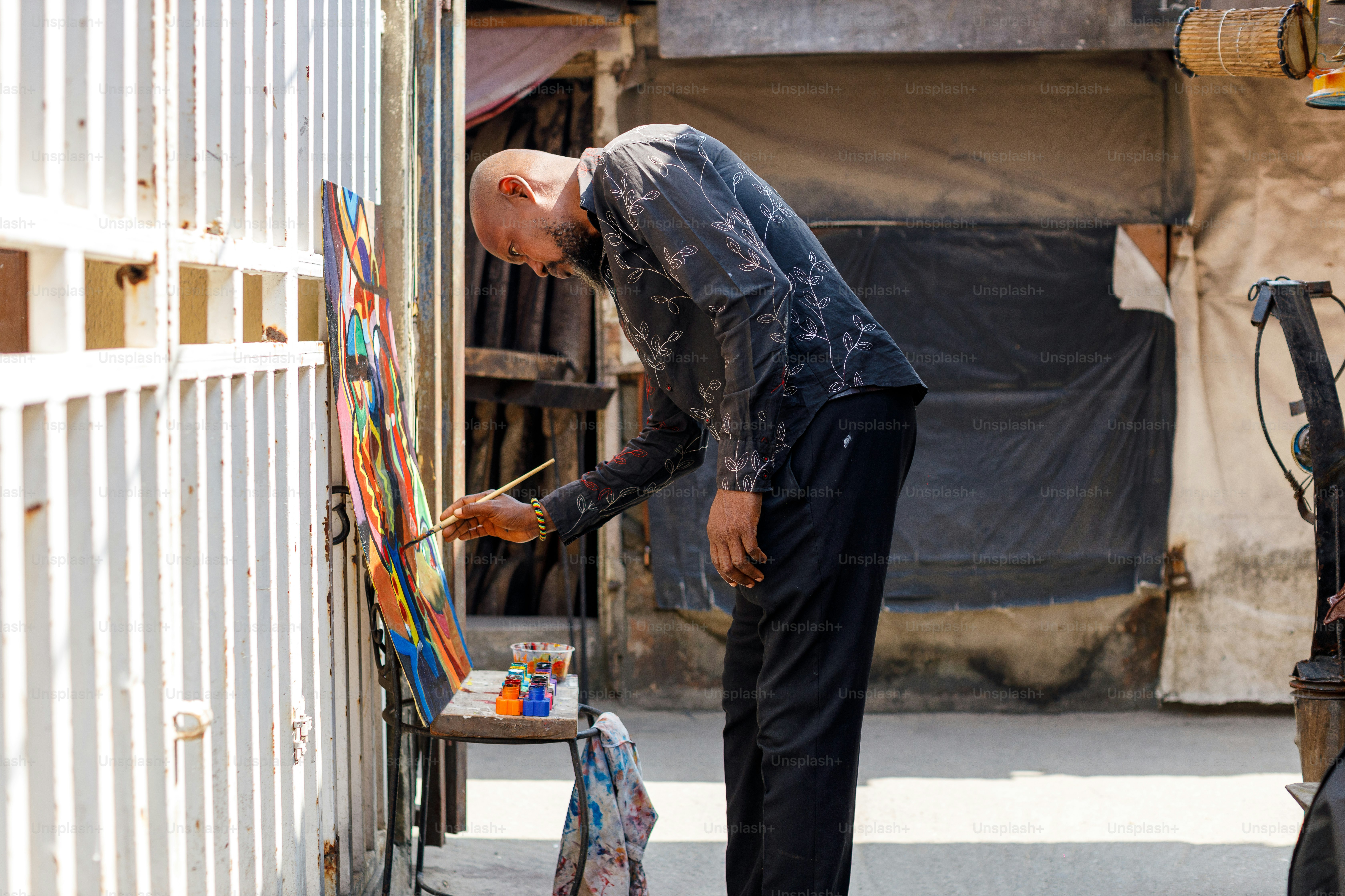 a man standing next to a painting on a easel