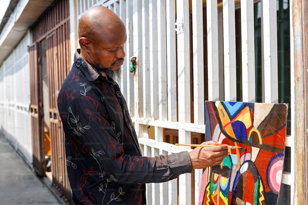 a man is painting a colorful piece of art