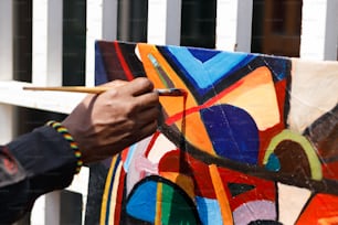 Ein Mann malt ein farbenfrohes Kunstwerk