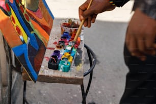 Ein Mann hält einen Pinsel in der Hand und malt auf einer Leinwand