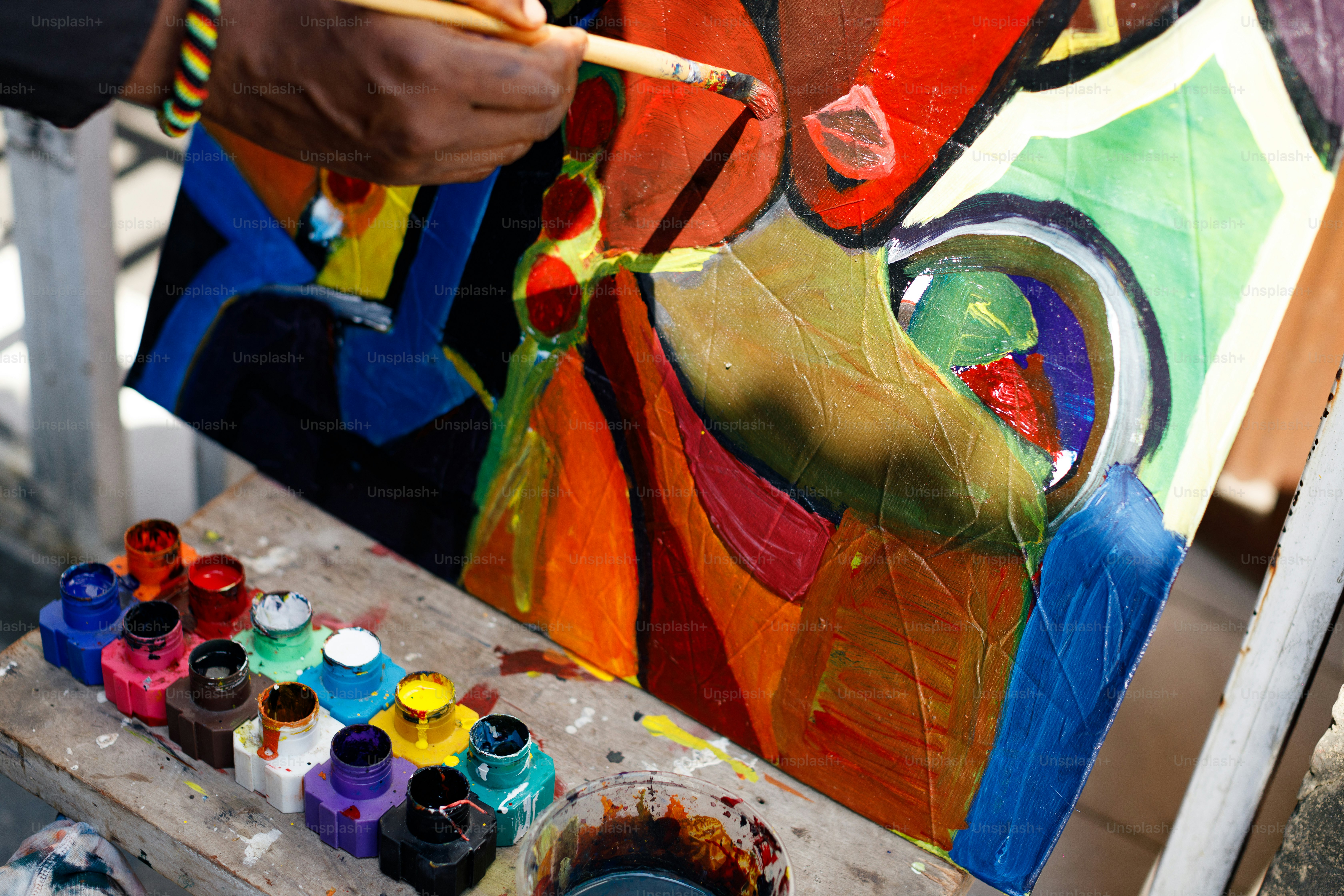 a man is painting a picture on a easel