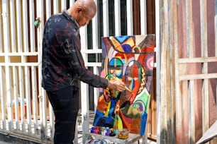 a man is painting a picture on a easel