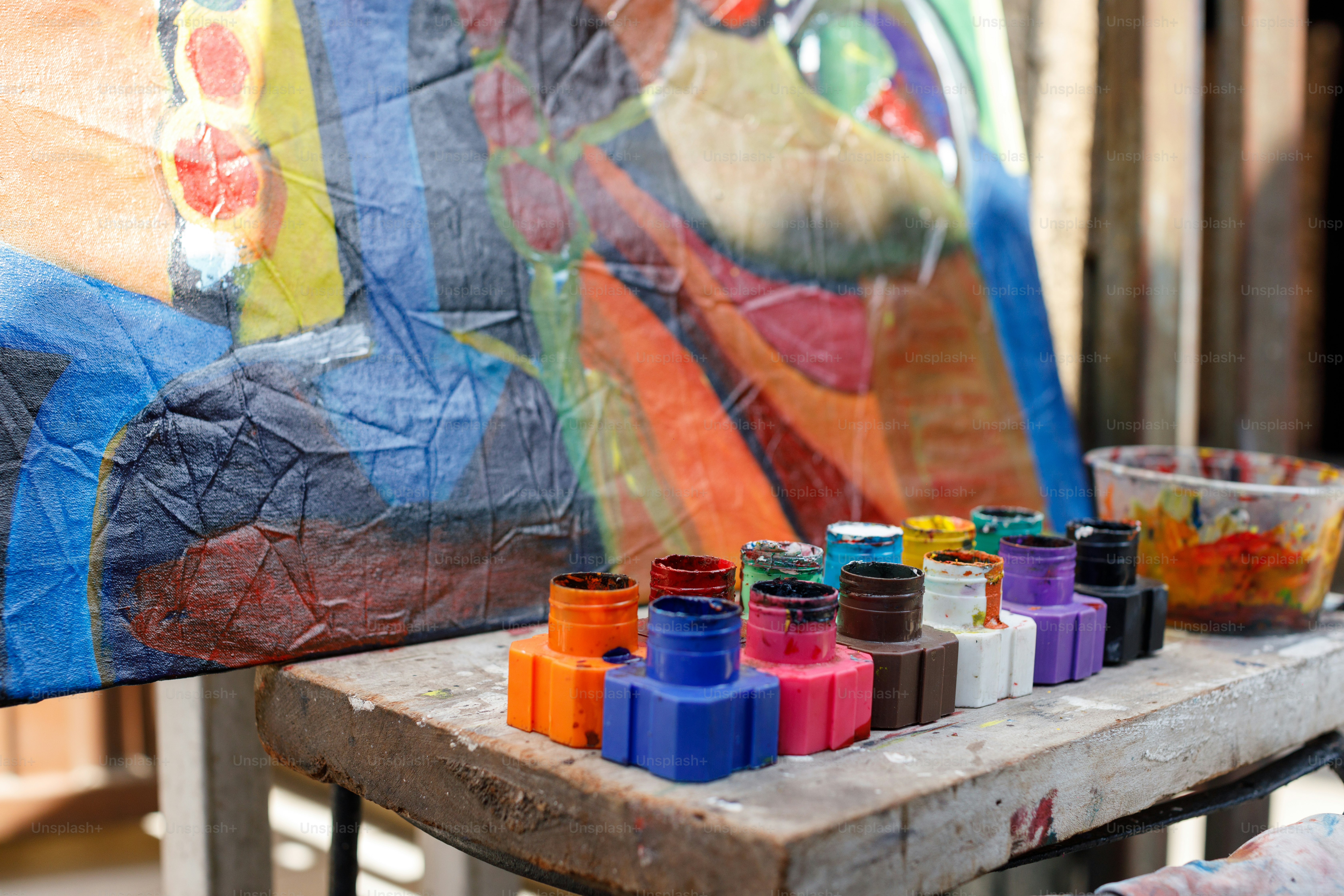 a wooden table topped with lots of colorful paints