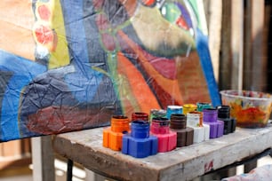 a wooden table topped with lots of colorful paints