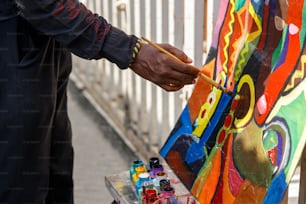 un homme tenant un pinceau peignant un mur coloré