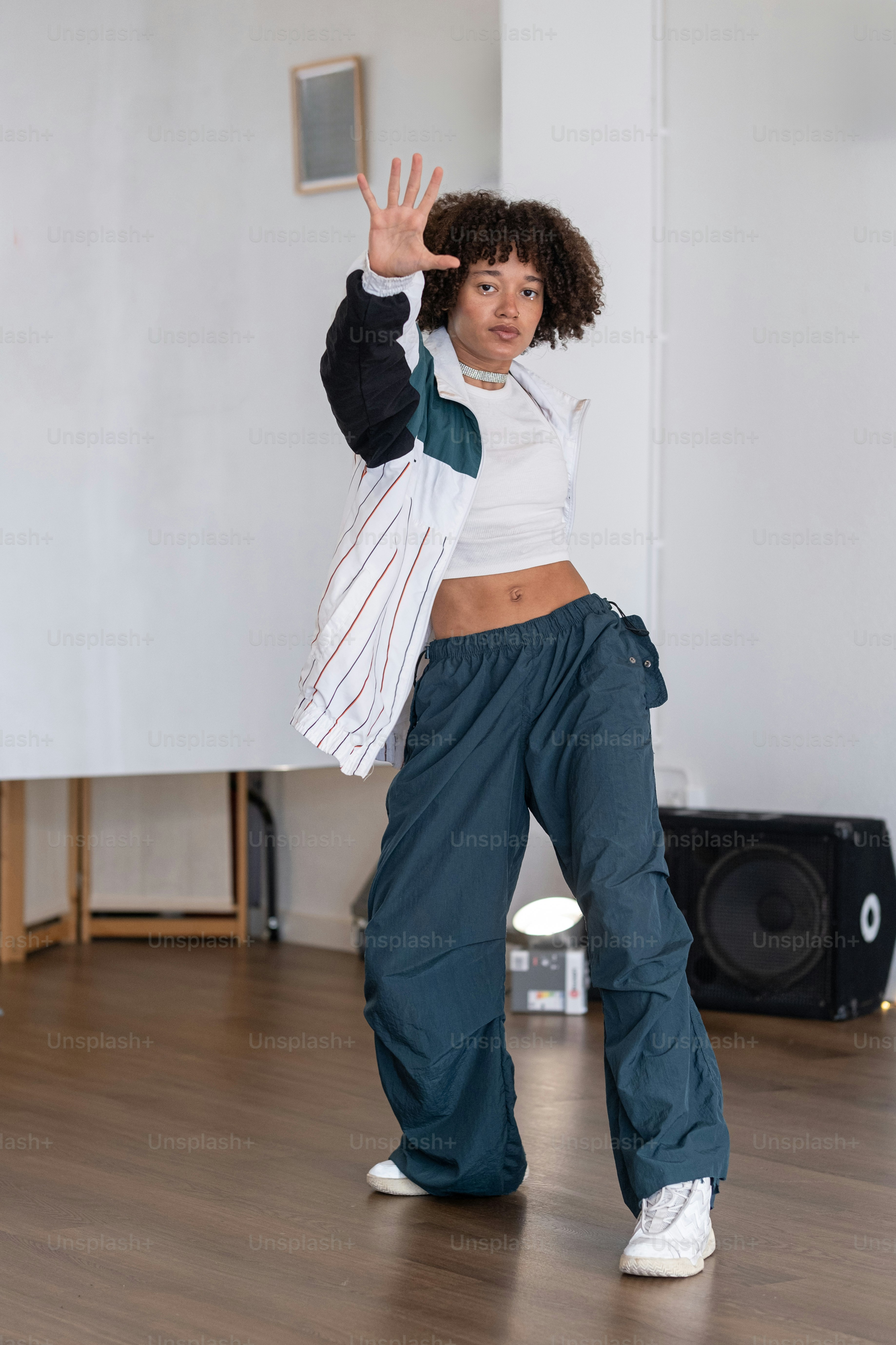 a woman standing on a wooden floor holding a bag