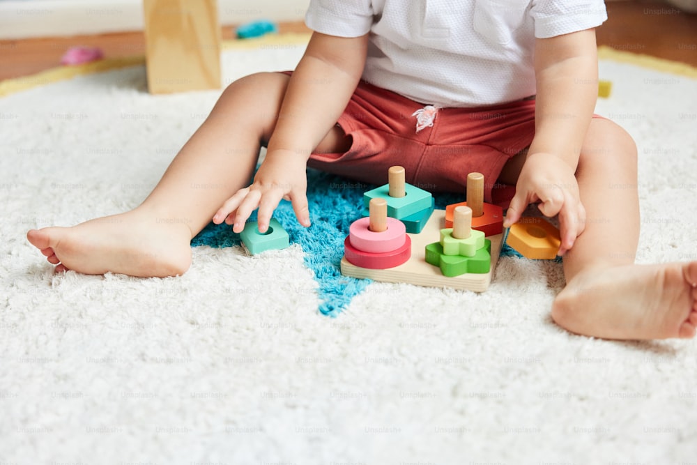 un tout-petit jouant avec des jouets sur le sol
