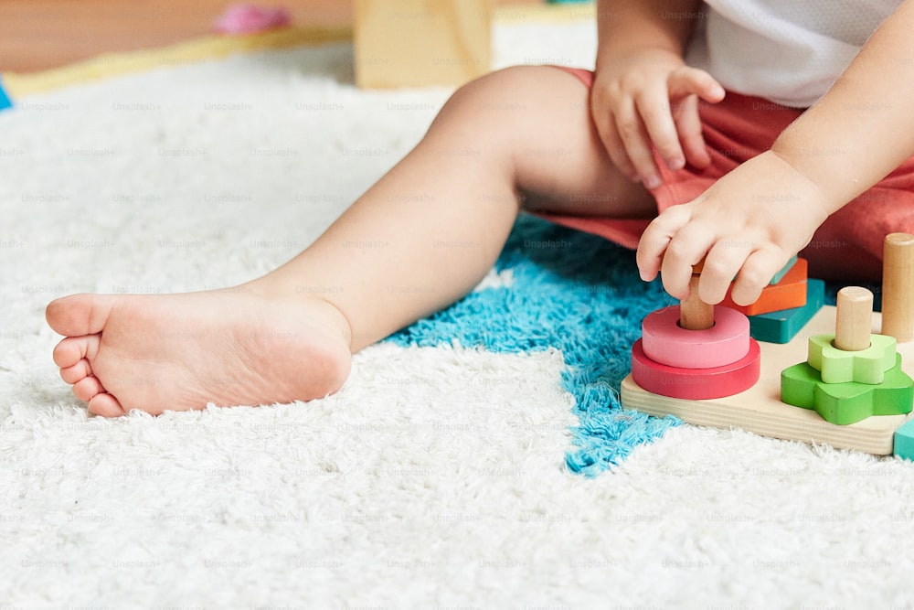 un bébé jouant avec un jouet sur le sol