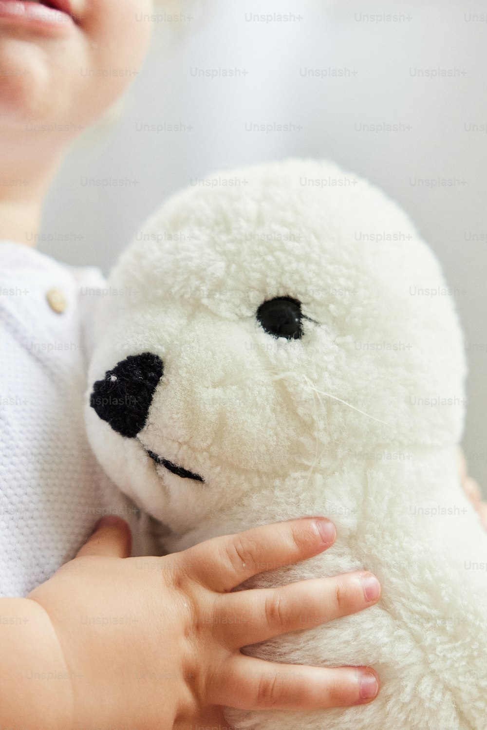 a small child holding a white teddy bear