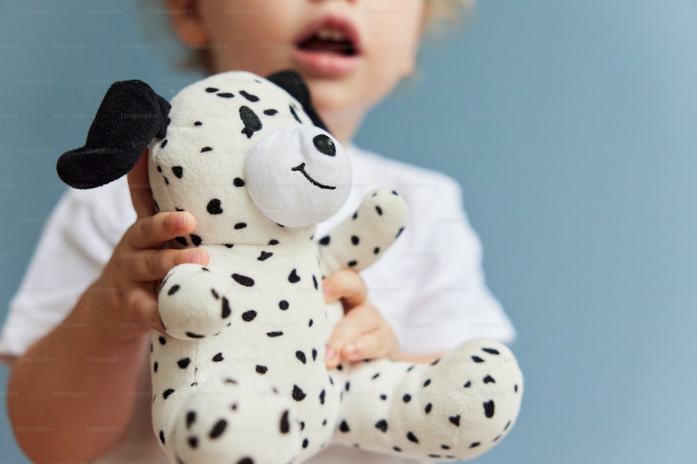 a young child holding a stuffed dalmatian dog