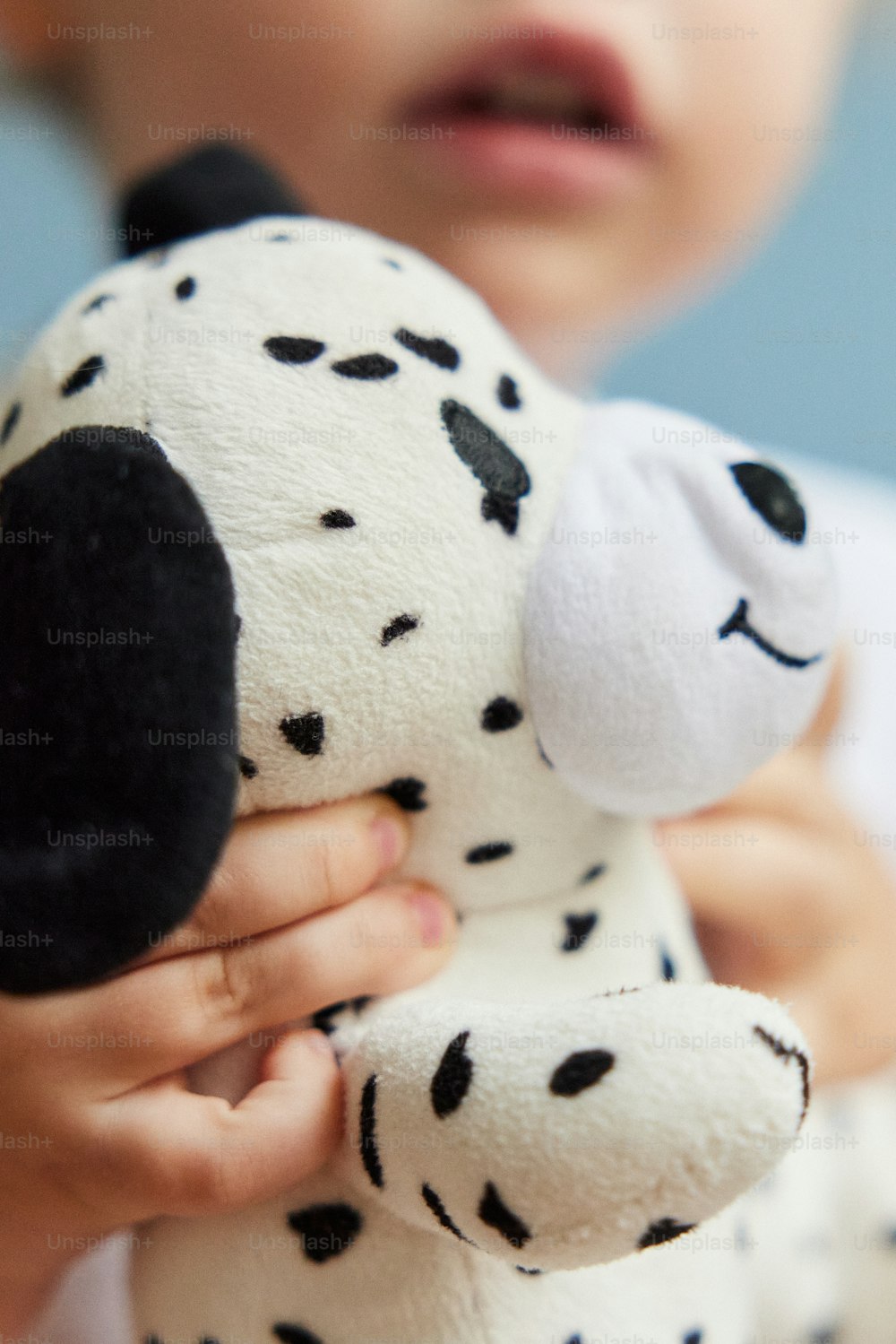 a small child holding a stuffed dalmatian dog