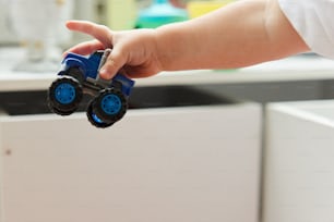 a person holding a toy truck in their hand