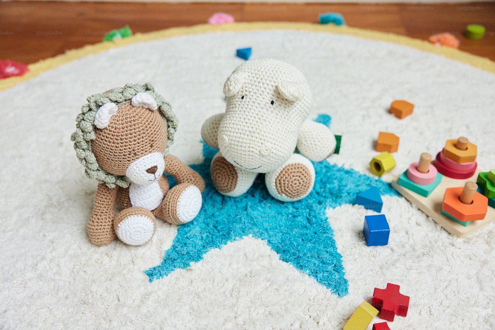 two crocheted teddy bears sitting on a rug