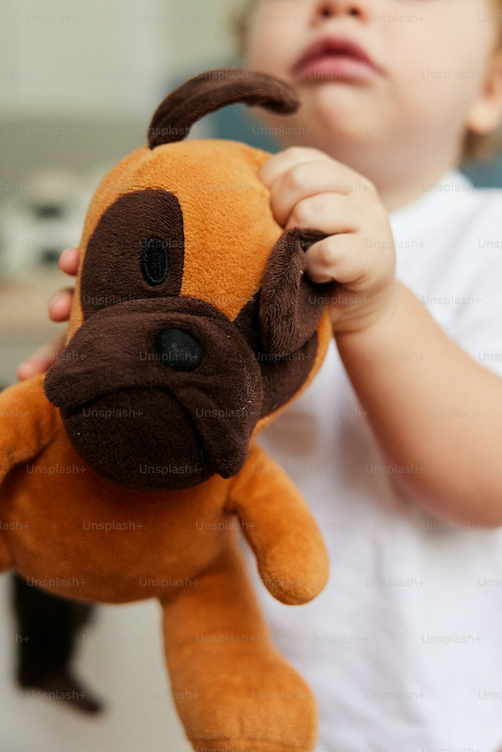 a little boy holding a stuffed animal in his hands