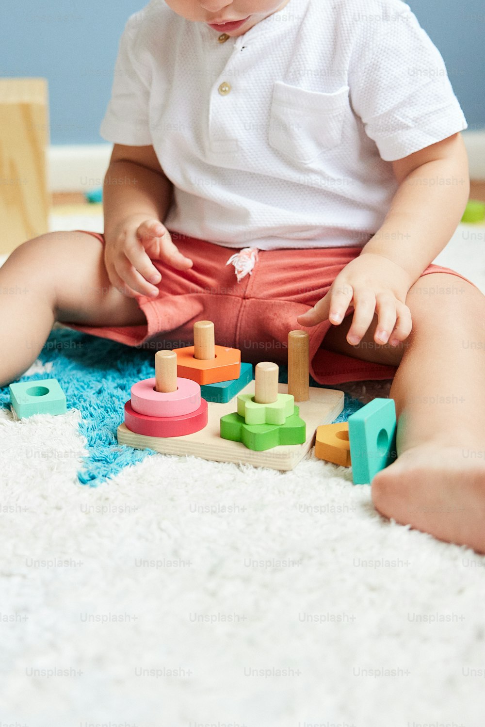 a toddler sitting on the floor playing with toys
