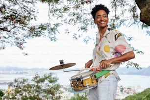 a man holding a drum and a pair of mallets