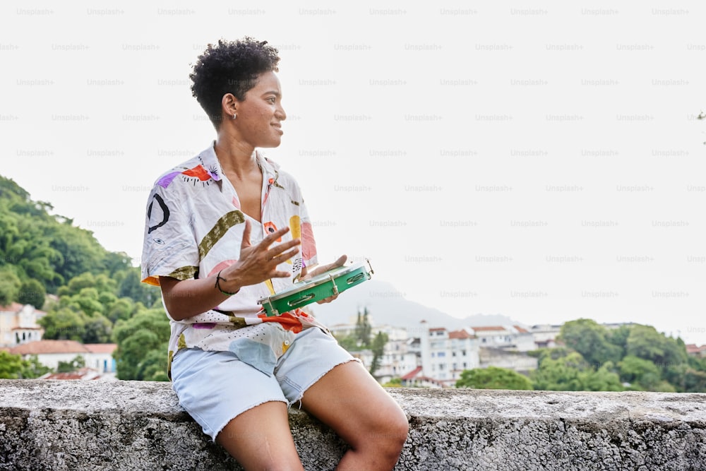 a woman sitting on a wall holding a book