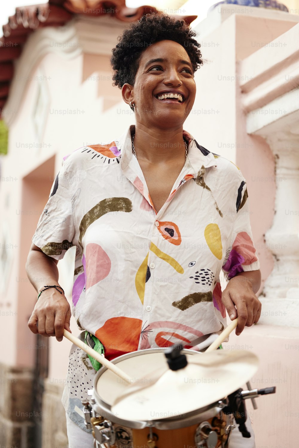 a woman is playing a drum outside