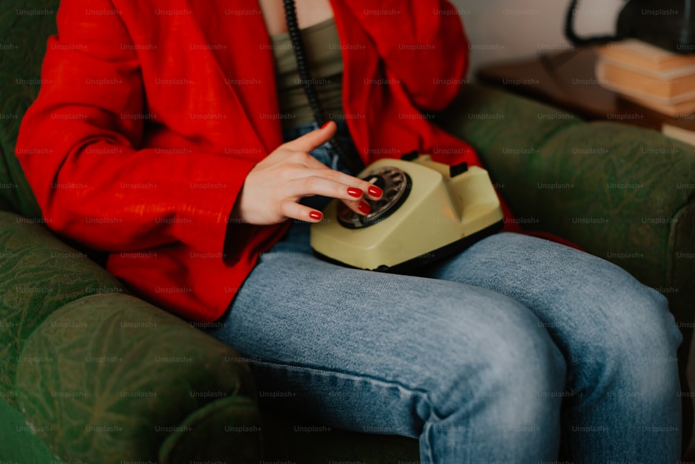 a woman sitting on a couch holding a phone