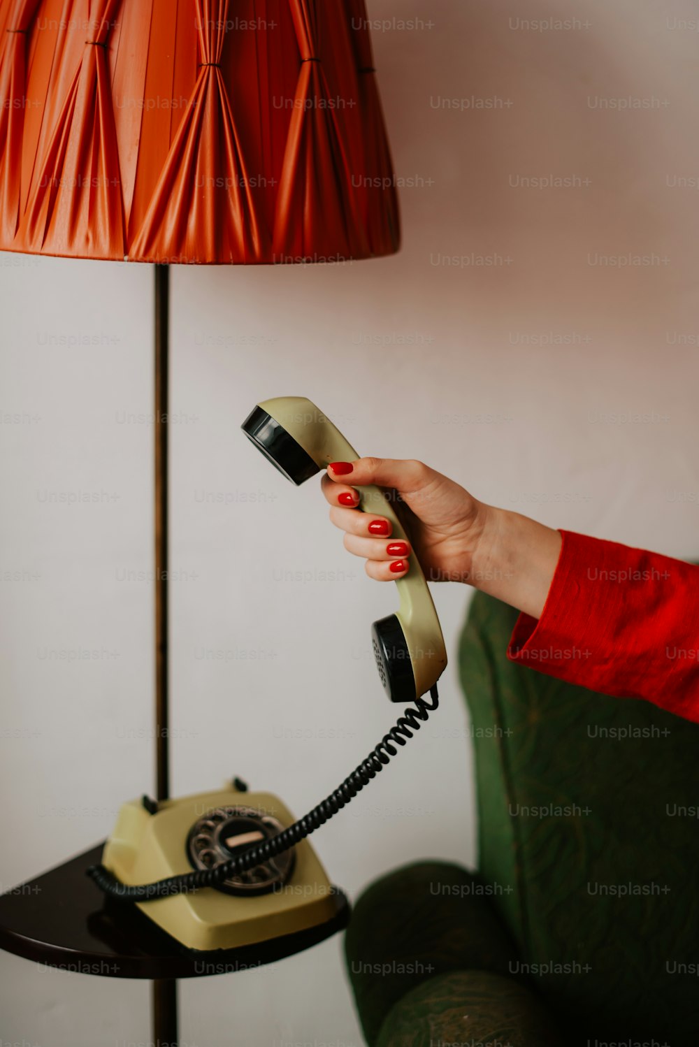 uma mulher segurando um telefone até uma lâmpada