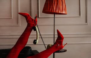 a woman in red stockings and heels laying on a couch