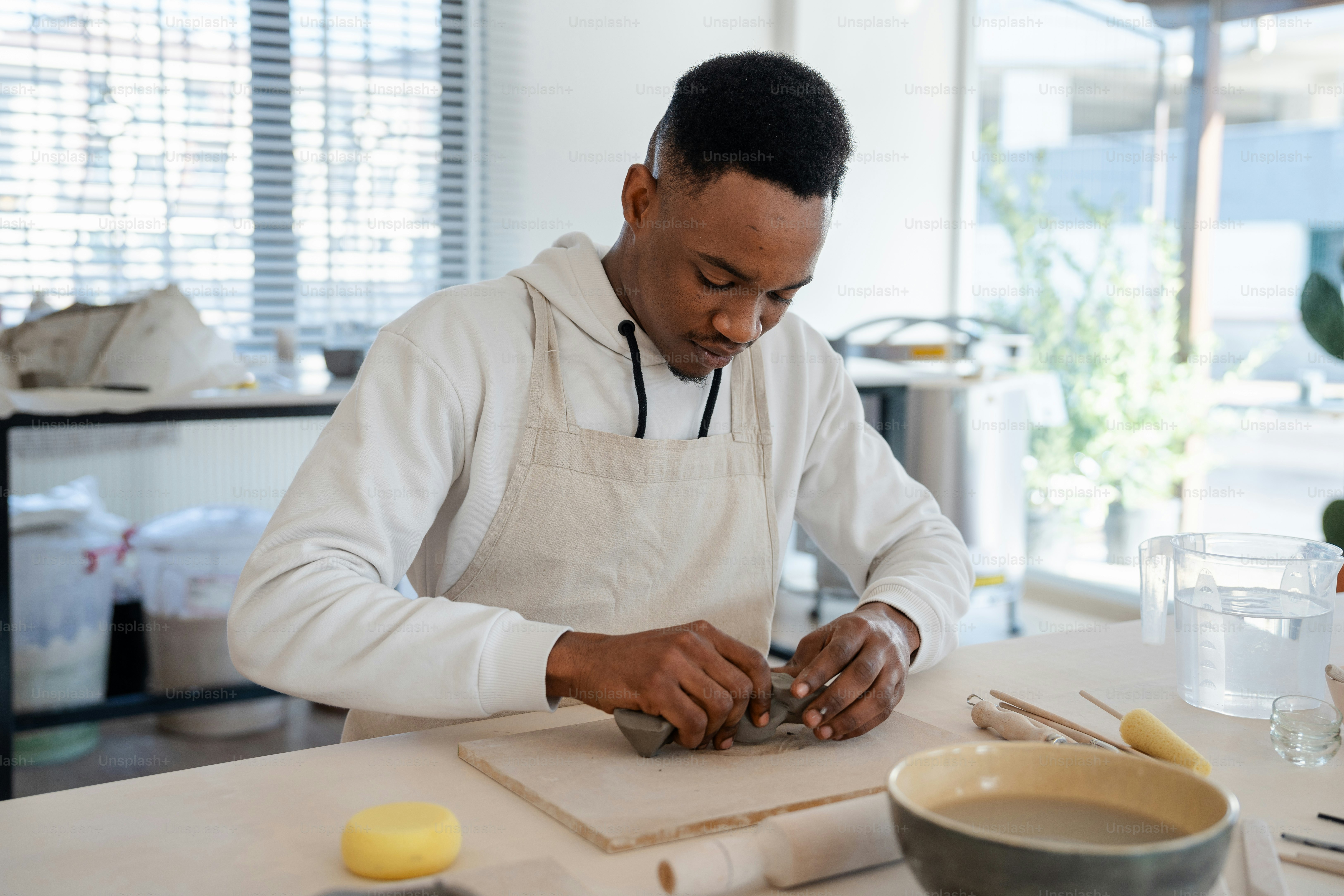 a man in an apron is making something on a table