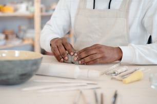 a man in an apron is working on a piece of pottery