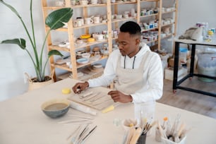 a man in a white shirt and apron working on a piece of paper