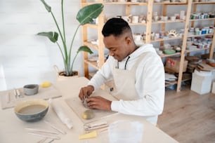 a man in a white jacket working on a piece of art