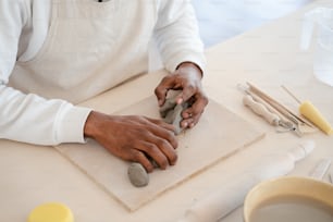 a man is using a stone carving tool on a piece of paper