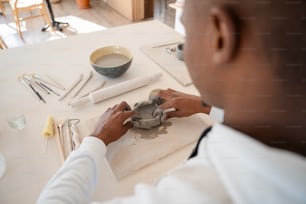 Un hombre está trabajando en una pieza de cerámica