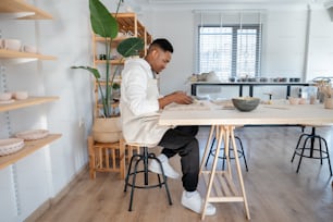 um homem sentado em uma mesa trabalhando em um pedaço de papel