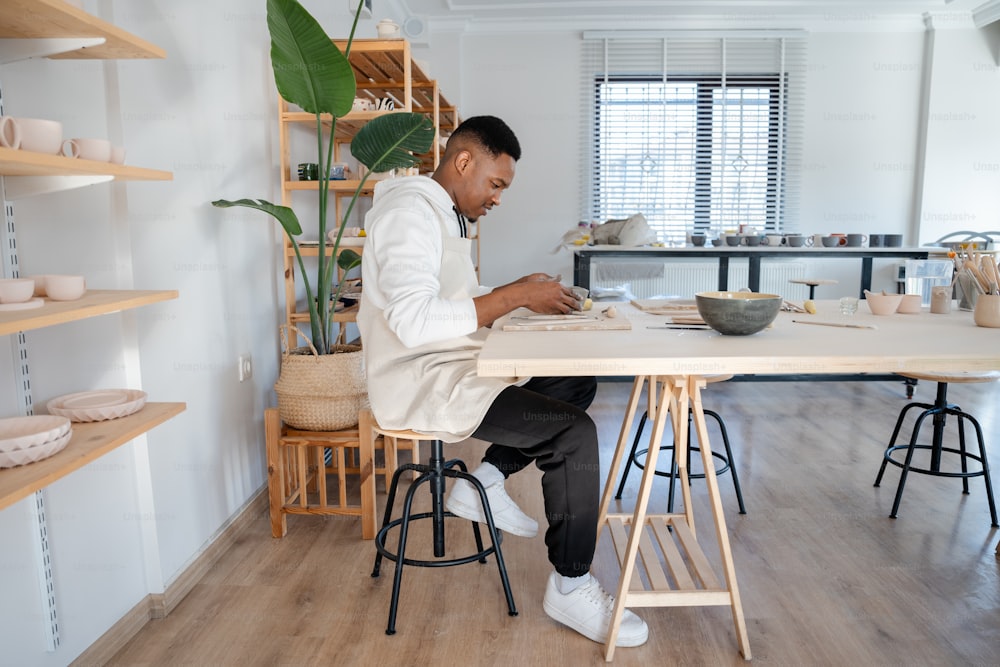 ein Mann sitzt an einem Tisch und arbeitet an einem Blatt Papier