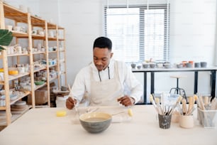 Un hombre con una bata blanca de cocinero preparando comida en una cocina